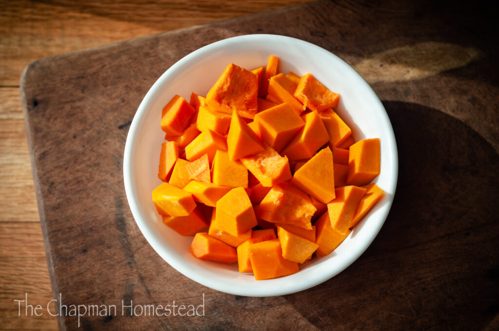 Photo of diced butternut squash in a white bowl.