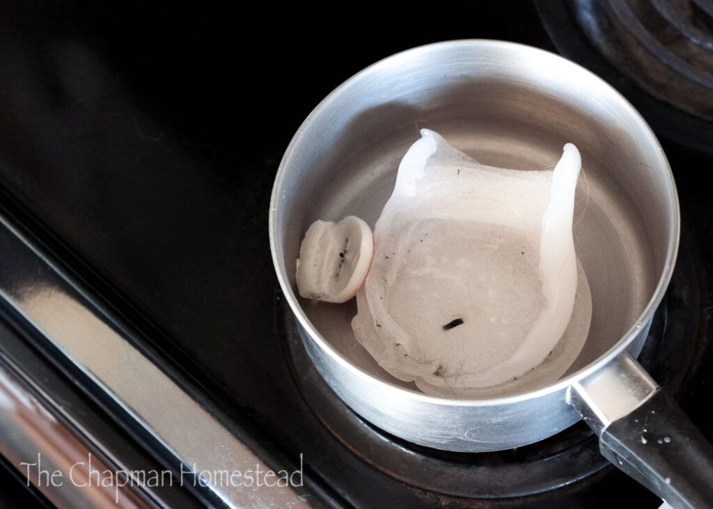 Photo of candle ends in a pot on the stove waiting to be melted down.